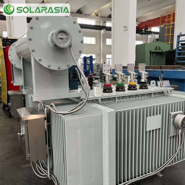 Technician performing a final quality check on a 1600kVA oil immersed transformer before packaging.