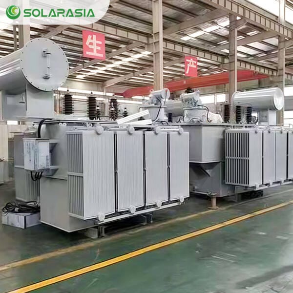 Multiple oil immersed power transformers lined up inside a modern factory, demonstrating production scale and manufacturing capability.