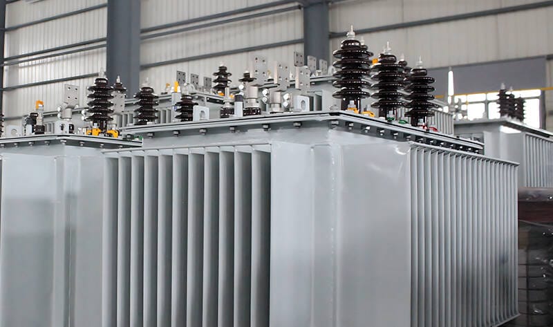 Inside view of a modern factory where skilled technicians are assembling a 30 kva oil immersed transformer.